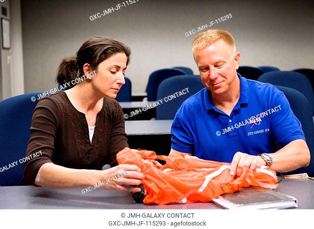 NASA astronauts Nicole Stott and Tim Kopra, both STS-133 mission specialists, participate in a classroom session of water survival training at NASA's Johnson...