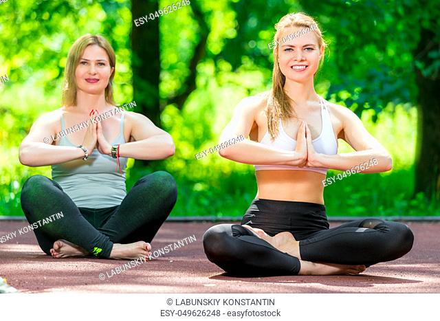 healthy lifestyle women doing yoga in the park in the lotus position