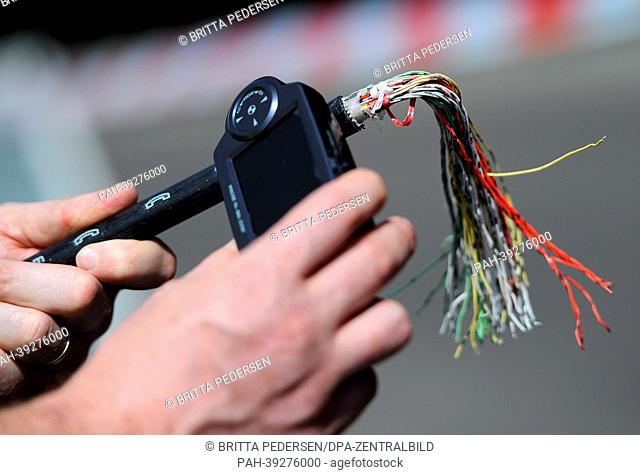 The presence of DNA material on a copper cable is proven with a magnifying glass in Berlin, Germany, 06 May 2013. A remote controlled helicopter is supposed to...