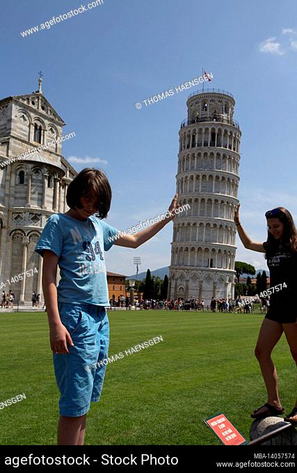 a typical tourist image of the leaning tower of pisa, toscany, italy, where the tourist looks as if he is supporting the tower