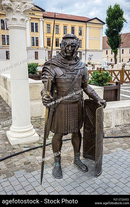 Roman legionary bronze statue in next to Roman ruins in Alba Carolina Fortress in Alba Iulia city located in Alba County, Transylvania, Romania