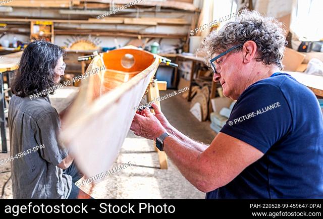 19 May 2022, Mecklenburg-Western Pomerania, Peenemünde: Frank Liwowski (r) and Sebastian Pöge (l) work on a two-seater in spearwood construction at the...