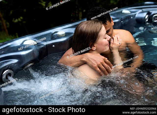 Young couple hugging in jacuzzi