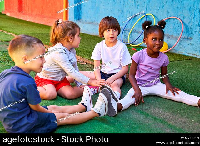 Gruppe Kinder macht Dehnübung im Sportunterricht der Vorschule oder im Kindergarten