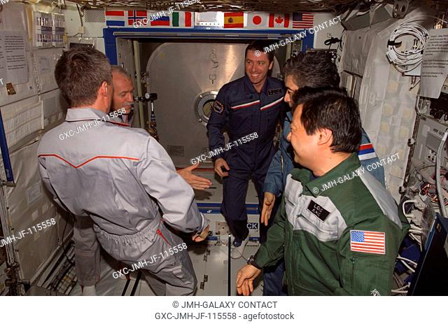 The crewmembers onboard the International Space Station (ISS) exchange greetings in the Destiny laboratory following the ceremony of Changing-of-Command from...