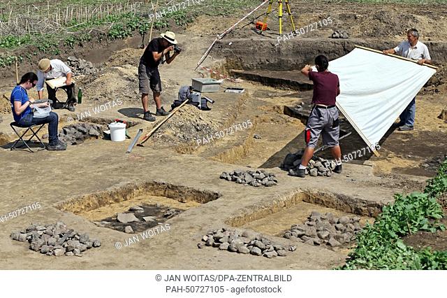Excavation workers document the location of the discovery of the fire pit near Worbzig,  Germany, 31 July 2014. An around 3000 year old meat processing facility...