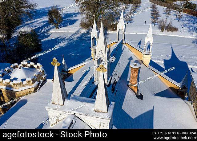 11 February 2021, Saxony-Anhalt, Wörlitz: The Gothic House casts its shadow into the winter garden kingdom of Dessau-Wörlitz