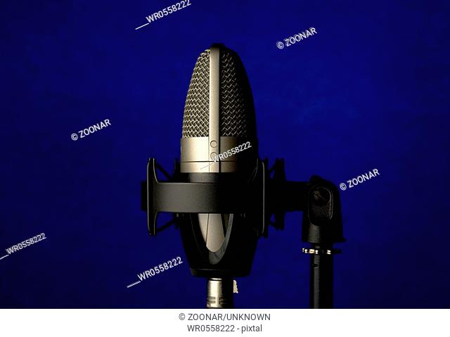 professional record studio microphone on abstract dark blue background