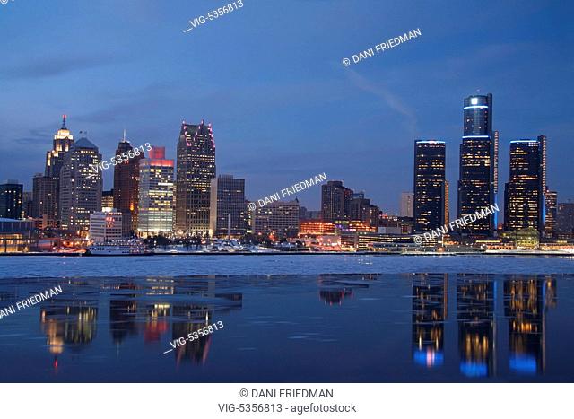 Skyline of downtown Detroit, Michigan, USA seen after sunset. Ice can be seen floating in the Detroit River. Detroit is known as The Motor City, The D, Motown