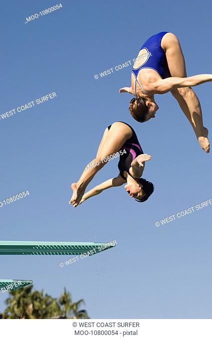 Two women diving from diving board