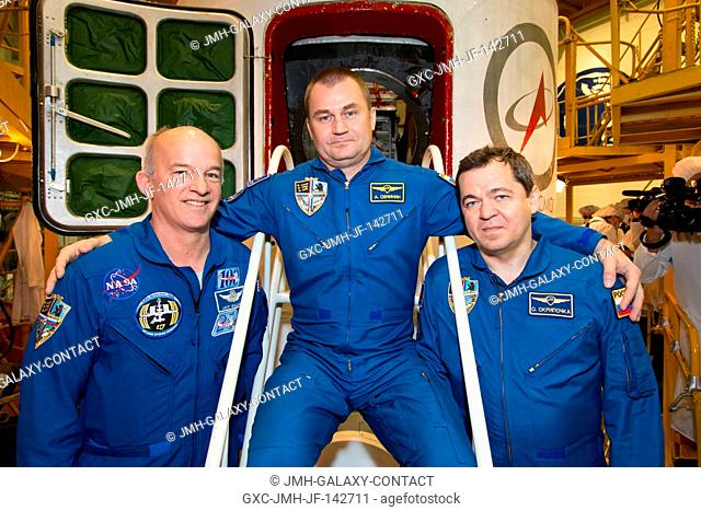 In the Integration Facility at the Baikonur Cosmodrome in Kazakhstan, Expedition 47-48 crewmembers Jeff Williams of NASA (left) and Alexey Ovchinin (center) and...