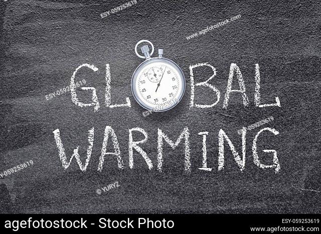 global warming phrase written on chalkboard with vintage stopwatch used instead of O