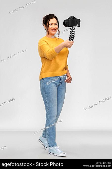 smiling woman blogger with camera recording video