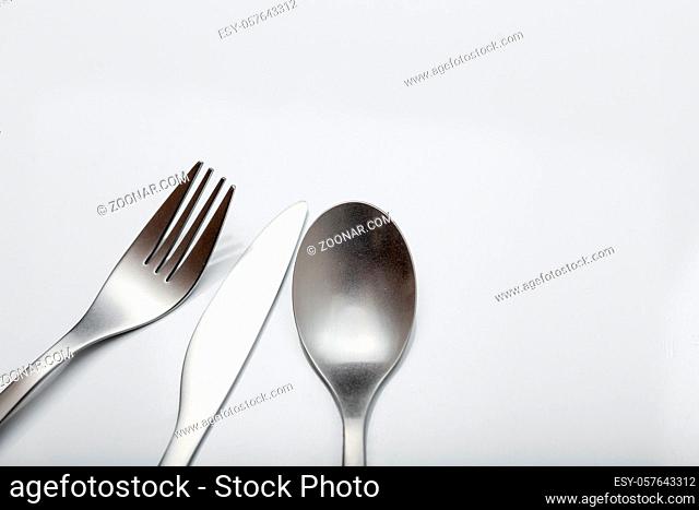 Cutlery on white table. Minimal designed fork, knife and spoon on clear, white background