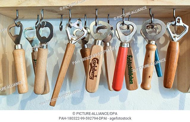 22 March 2018, Germany, Arensdorf: Different bottle openers hanging underneath a shelf in the party basement of Klaus Dieter Burau