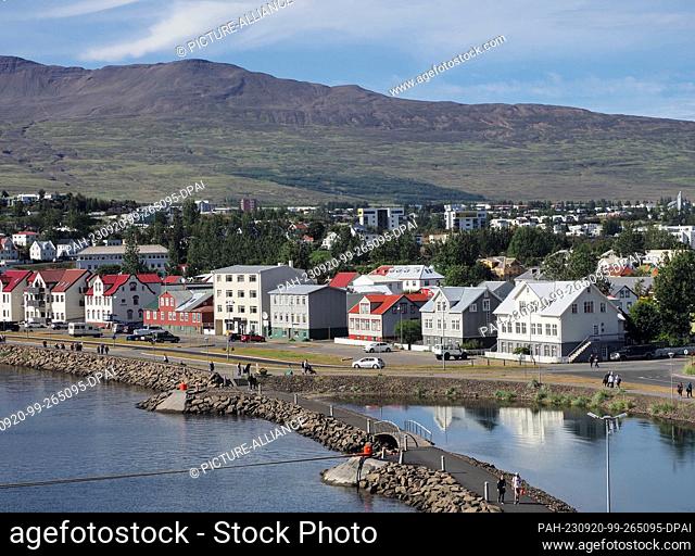 20 August 2023, Iceland, Akureyri: Residential and commercial buildings below a mountain near the port. Photo: Soeren Stache/dpa
