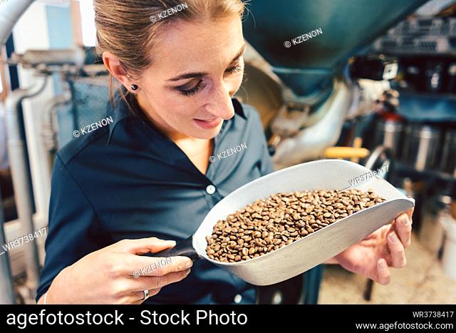 Woman in coffee roastery with fresh beans full of aroma