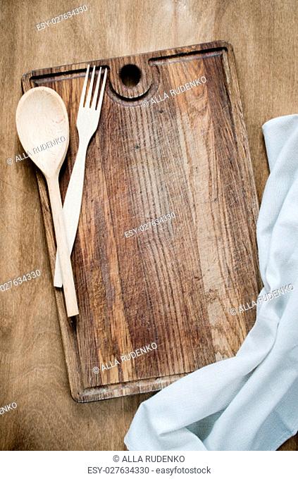 Kitchen Background: Rustic Cutlery with Kitchen Towel or Napkin on Wooden Board Over the Rustic Wooden Table. View From Above With Copy Space