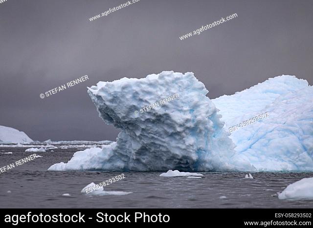 Beautiful iceberg up close with detail of blue shimmering ice on surface with mood lighting