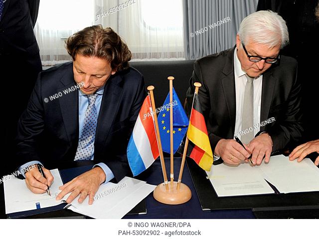 German Foreign Minister Frank-Walter Steinmeier and Dutch Foreign Minister Bert Koenders (L) sign the treaty on board the mult-purpose ship ""Neuwerk"" in the...