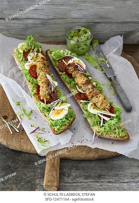 Chicken kebabs on ciabatta with an avocado dip, lollo bionda lettuce, tomatoes and hard-boiled eggs
