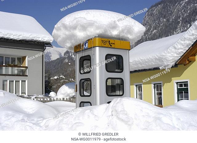 Telephone box snowed under with big weight of snow