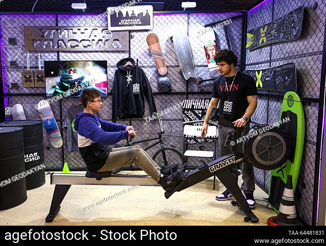RUSSIA, MOSCOW - 6 de noviembre de 2023: Un niño utiliza una máquina de ejercicios en un stand de la marca Ulichnaya Klassika [Street Classics] streetwear...