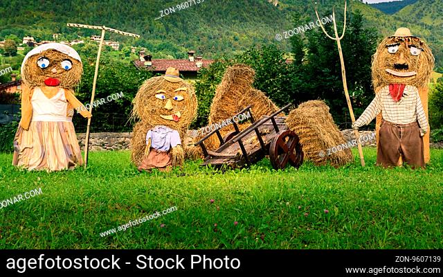 Lovely farmers family Puppets(straw dolls) made out of Hay Bale with typical peasant clothes in europe autumn, square photo