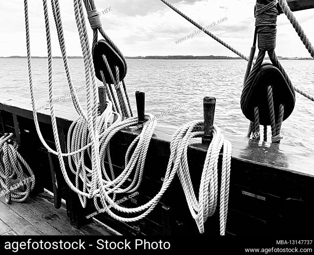 Belay nails with raised ropes on the railing of the historical merchant ship Lisa von Lübeck