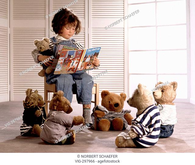 Little girl reading her teddys something from a picture book. - 18/06/2006