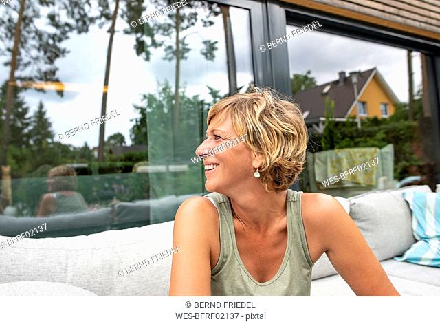 Happy woman relaxing on terrace at home