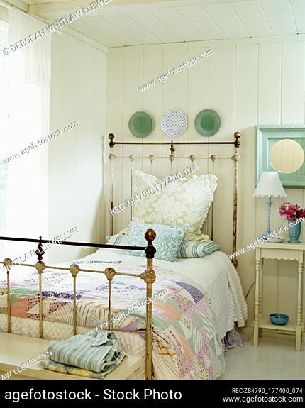 Old fashioned brass single bed in country style bedroom
