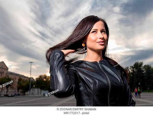 russian brunette 20s years old posing outdoors weared black leather jacket