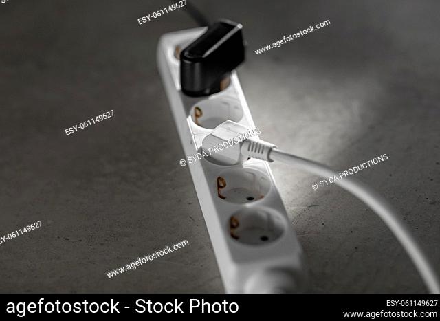 close up of socket with plugs and charger on floor