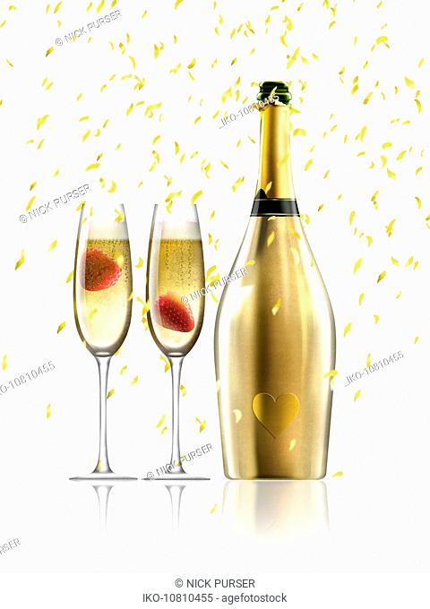 Confetti falling on two glasses of champagne next to gold champagne bottle