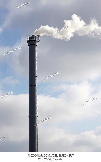 industrial chimney or smokestack emitting white smoke into atmosphere