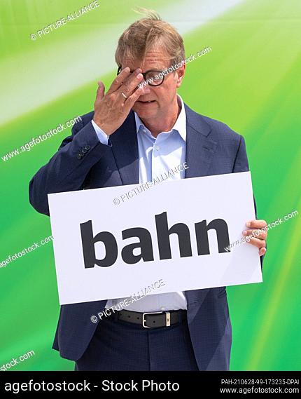 28 June 2021, Hessen, Frankfurt/Main: Ronald Pofalla, Deutsche Bahn's Chief Infrastructure Officer, holds a sign with the words ""bahn"" in his hands and...
