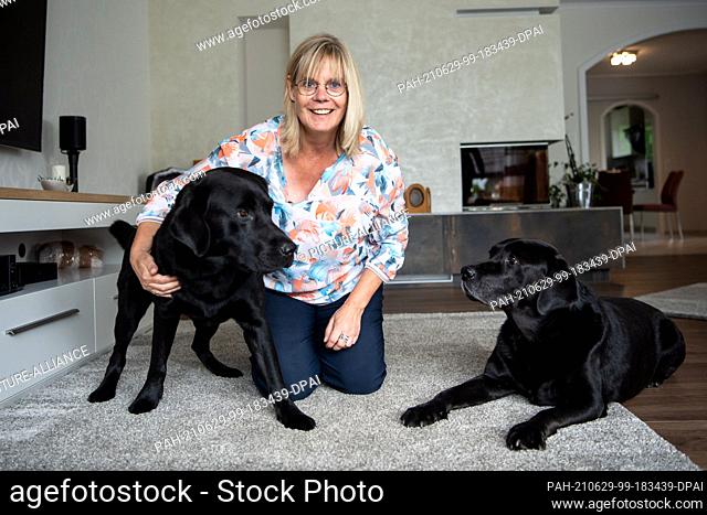 PRODUCTION - 23 June 2021, Lower Saxony, Delmenhorst: Claudia Kasig sits next to her bed bug sniffing dogs Ramirez and Jamiro