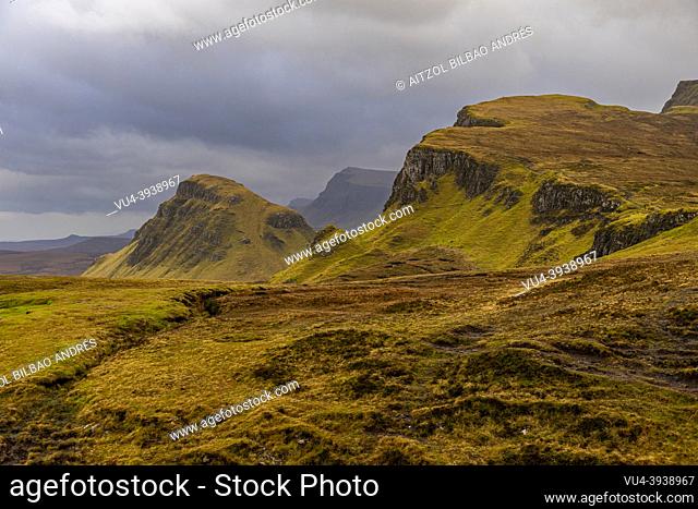 The Quiraing, big cliff, cloudy day, sun rays, mountain landscape, Skye Island, Highlands, Scotland