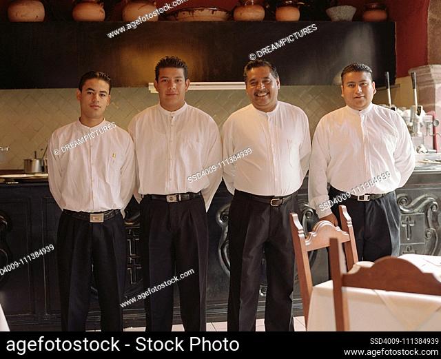 Four men standing in a row in restaurant