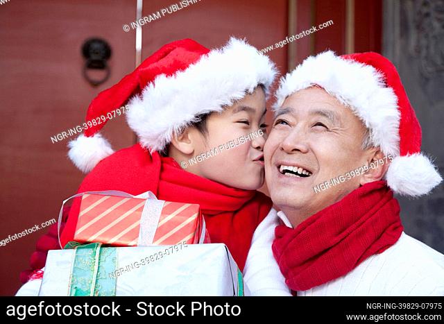 Grandpa and grandson holding Christmas Gifts