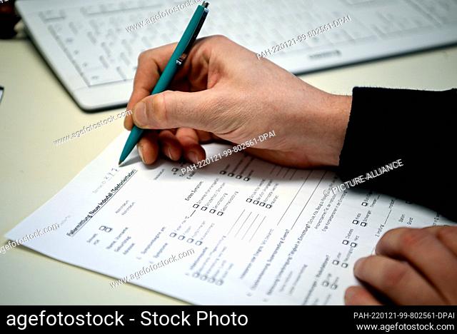 20 January 2022, Berlin: Thomas Tobin, a member of the pandemic staff at the Neukölln Health Department, fills out a form for a case investigation at a nursing...