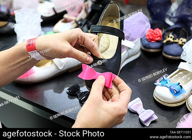 RUSSIA, MOSCOW - APRIL 28, 2023: A staff member at a shoe display during the Moscow Fashion Week at the Oceania Shopping Centre