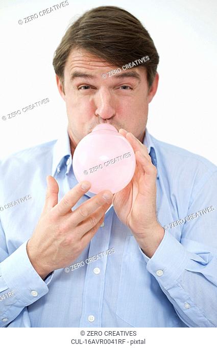 man trying to blow a balloon