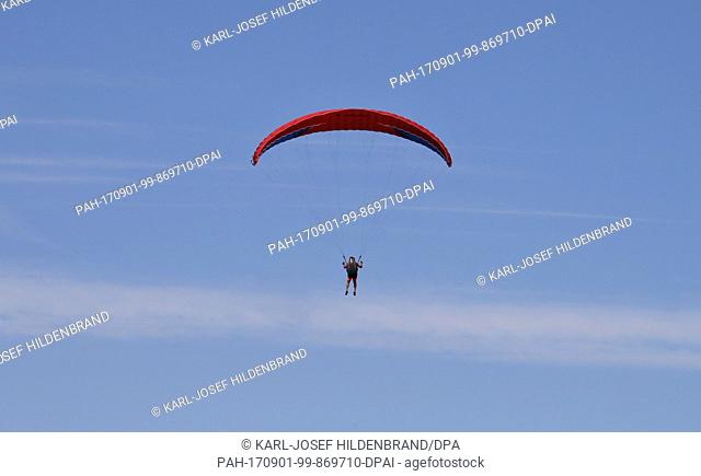 A pupil of the paragliding school during their examination flight near Schwangau, Germany, 30 July 2017. Photo: Karl-Josef Hildenbrand/dpa