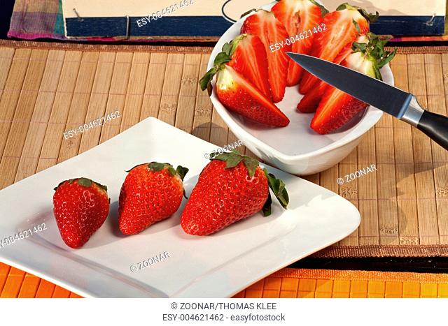 Fresh red Strawberries on a plate some in a bowl