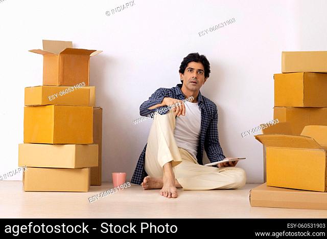 Indian man thinking with tablet during shifting to new home