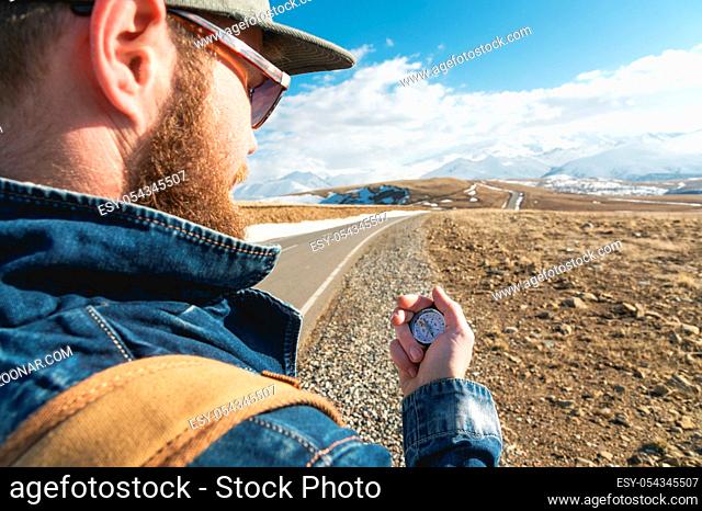 Close-up Hipster man using a compass on a snowy mountain