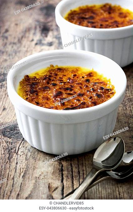 Traditional French creme brulee on rustic wooden table