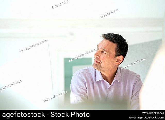 Mature businessman looking away at office
